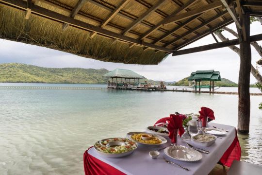 A table set under the gazebo, calm sea beyond